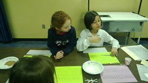Here Natalie and Chloe are making braile cards with their names on them