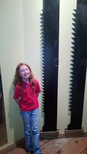 Natalie standing next to a two-man saw